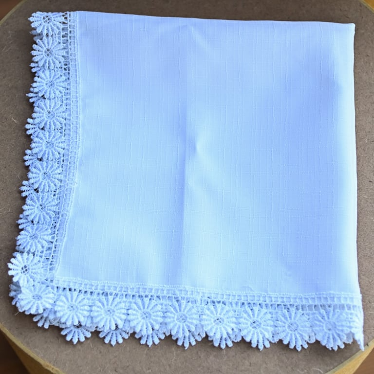 Guardanapo de tecido branco com acabamento em bordado