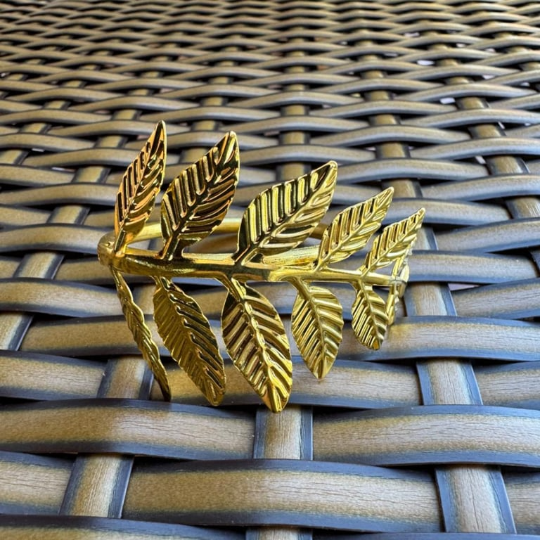 Porta-guardanapo dourado com ramo de folhas