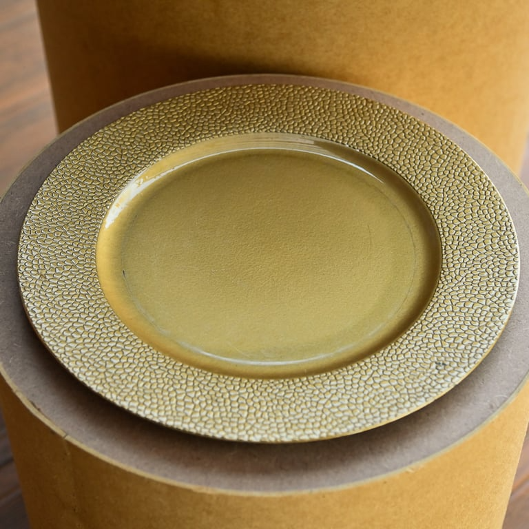 Sousplat dourado com acabamento texturizado em relevo